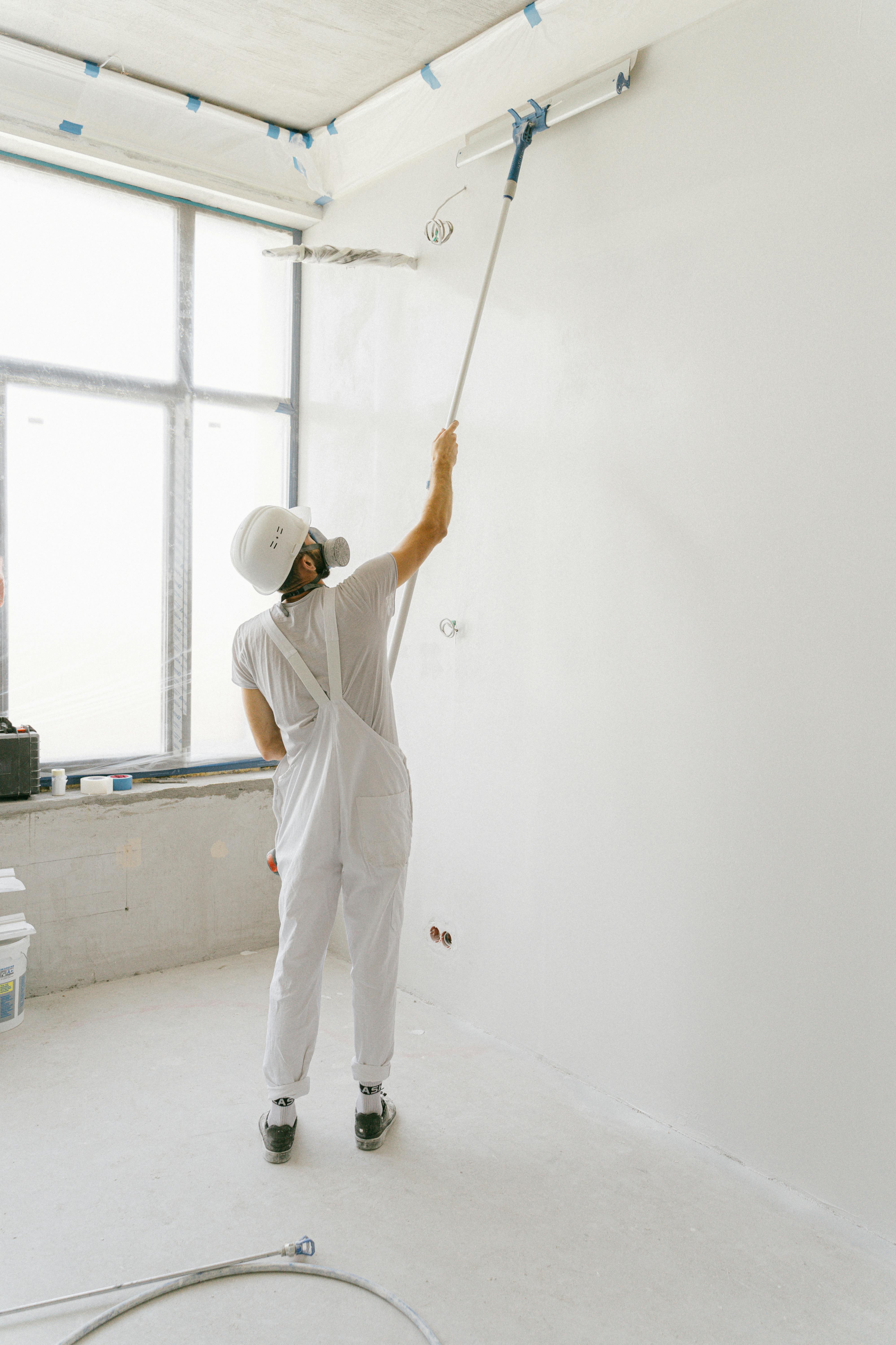 Pintor profissional a pintar uma parede interior